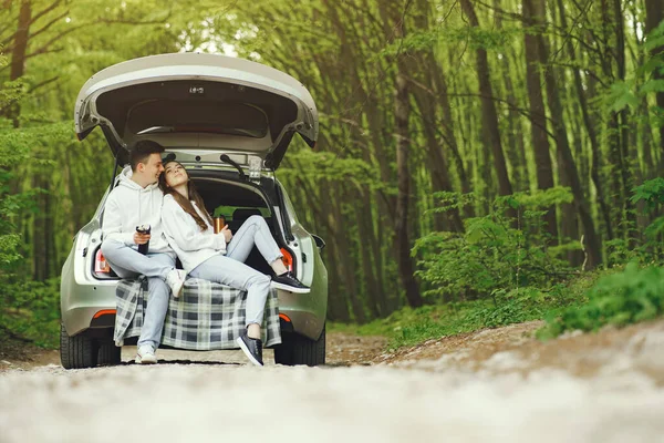 Пара в лісі сидить у багажнику — стокове фото