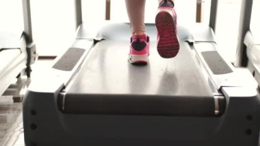 Spor salonunda koşu bandında koşan bir kız