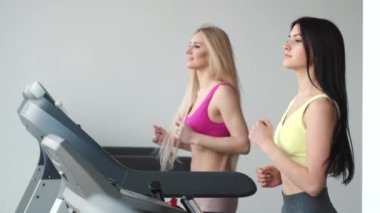 Spor salonunda koşu bandında koşan bir kız