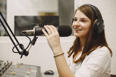 Radyo sunucusu mikrofonla konuşuyor.