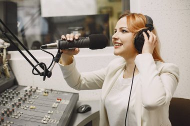 Radyo sunucusu mikrofonla konuşuyor.