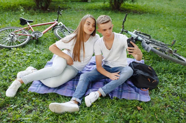 Casal sentado em um parque com bicicleta — Fotografia de Stock