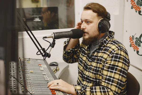 Radyo sunucusu mikrofonla konuşuyor.