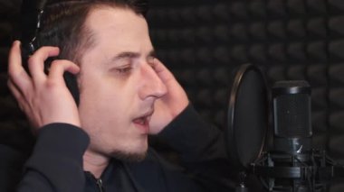 Kayıt stüdyosunda şarkı söyleyen genç adam.