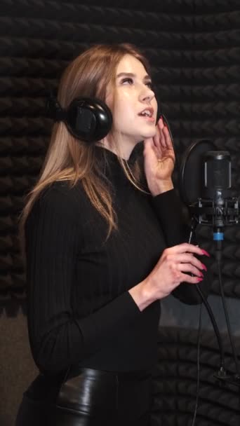 Певица, записывающая песню в музыкальной студии — стоковое видео