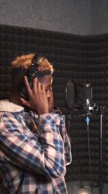 Kayıt stüdyosunda şarkı söyleyen genç adam.