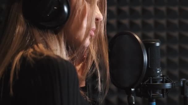 Певица, записывающая песню в музыкальной студии — стоковое видео