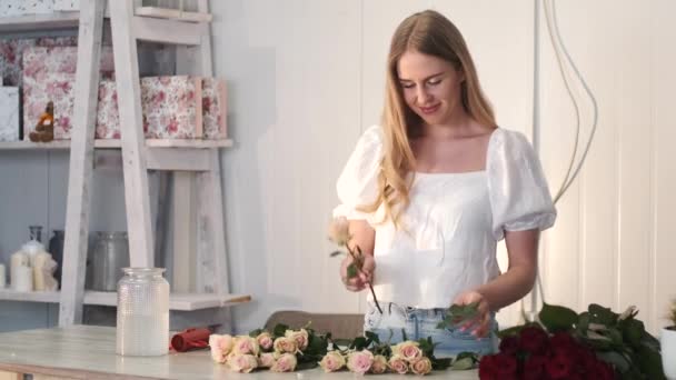 Donna ctting e smistamento rose nel negozio di fiori — Video Stock