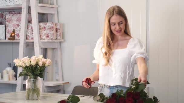 Hermosa florista femenina arreglando ramo en una tienda — Vídeos de Stock