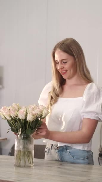 Kwiaciarnia stawia świeże róże w wazonie w kwiaciarni — Wideo stockowe
