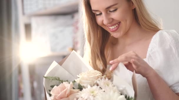 Mujer joven apreciando fragancia ramo de flores — Vídeos de Stock