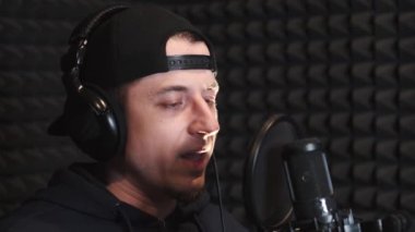 Kayıt stüdyosunda şarkı söyleyen genç adam.