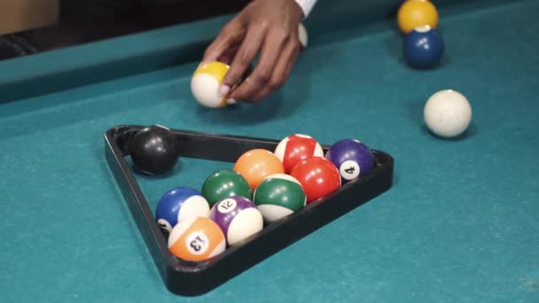 Man puts on the pool table balls in a triangular frame — Stockvideo