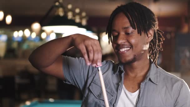 African American guy rubbing chalk on a cue — стокове відео