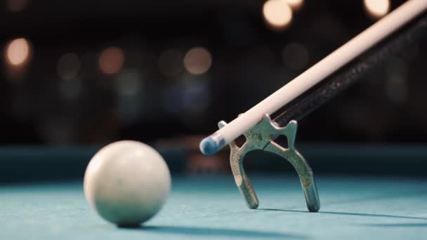 Jogador de bilhar masculino se prepara para acariciar uma bola com cue stick usando descanso — Vídeo de Stock