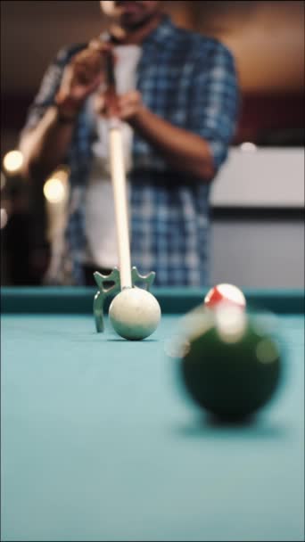 Jogador de bilhar masculino se prepara para acariciar uma bola com cue stick usando descanso — Vídeo de Stock