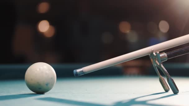 Male billiard player gets ready to stroke a ball with cue stick using rest — Stockvideo
