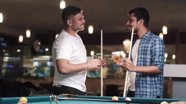 Двоє молодих красивих чоловіків грають у басейні в барі — стокове відео