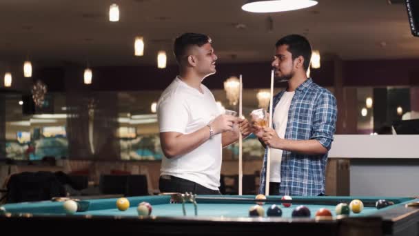 Two young handsome men playing in pool at bar — Video