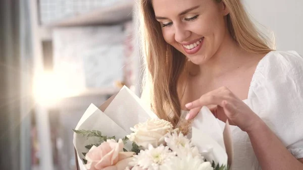Mujer joven apreciando fragancia ramo de flores — Foto de Stock