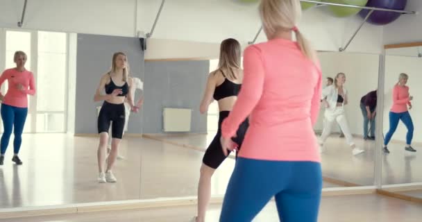 Entrenadora de fitness femenina que lidera una clase en el gimnasio — Vídeo de stock