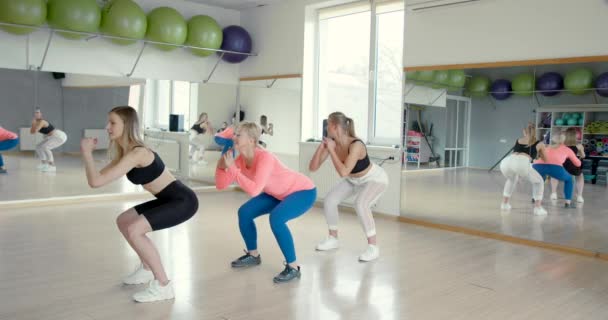 Női fitness edző vezeti az osztályt az edzőteremben — Stock videók