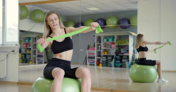 Sportovní dívka s fitness míčkem cvičení v posilovně — Stock video