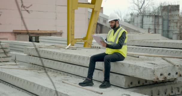 Egyetlen dolgozó ember szabadban Építőipari jegyzettömbbel — Stock videók