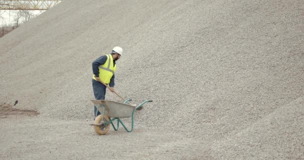 Areia manual de escavação do trabalhador com pá no local de construção — Vídeo de Stock