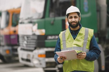 İnşaat mühendisi dışarıda kaskla çalışıyor.