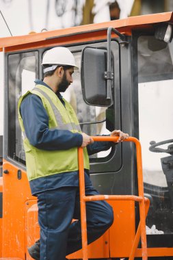 İnşaat mühendisi dışarıda kaskla çalışıyor.