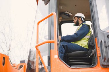 İnşaat mühendisi dışarıda kaskla çalışıyor.