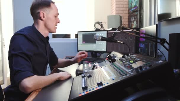 Звукорежисер, що працює в студії з обладнанням — стокове відео