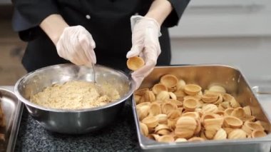 Üniformalı kadın aşçı ticari mutfakta yemek pişiriyor.