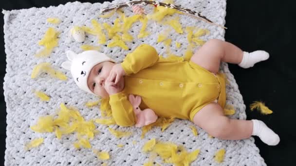 Cute little baby w żółtym stroju leżącego na kratę — Wideo stockowe