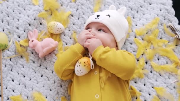Симпатична маленька дитина в жовтому костюмі лежить на плоскому — стокове відео