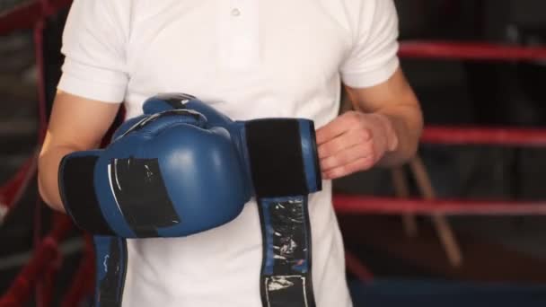 Um boxeador masculino coloca luvas de boxe no ginásio — Vídeo de Stock