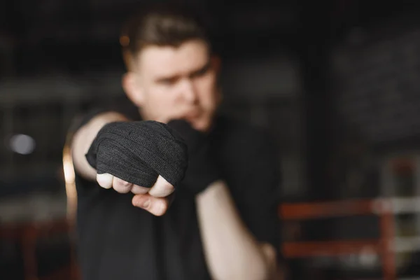 Man in een zwart t-shirtg boksen in een sportschool — Stockfoto