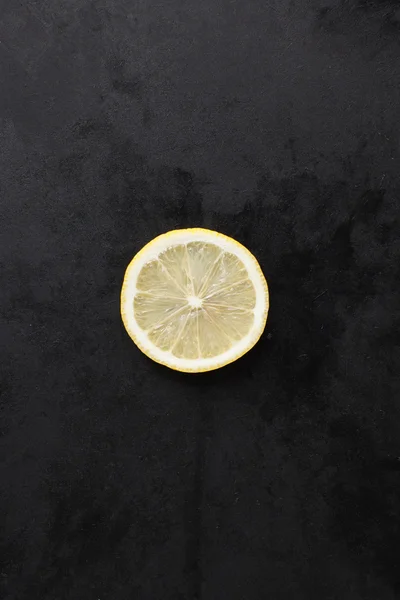 Zitronenscheibe auf schwarzem Hintergrund — Stockfoto