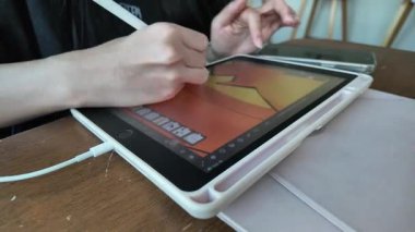 Close-up of woman's hand using stylus pen to draw on tablet. Concept of hobby, creating art with electronic devices during holidays at the cafe.