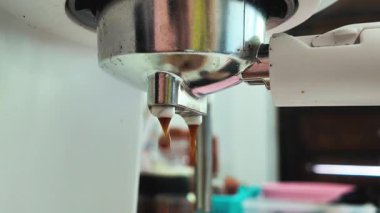 Kahve makinesinden fincana damlayan kahvenin yakın görüntüsü. Sabah sıcak kahveyle kendine çeki düzen ver, kahvaltı içkisi..