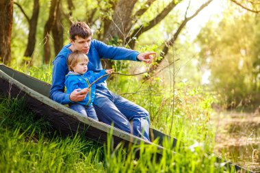 Baba ve oğlunun bir tekne göl kenarında oturan ve balık yakalamak