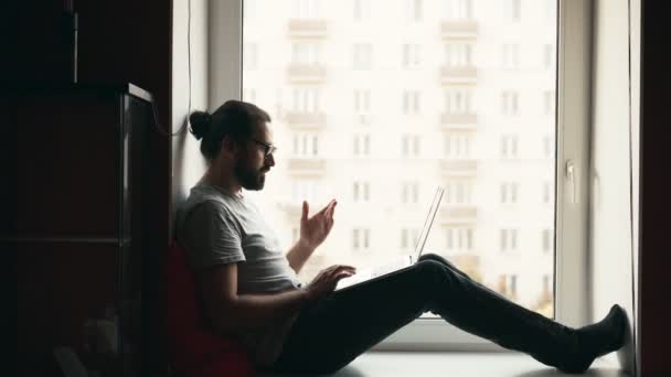 Jonge knappe deelname aan een videoconferentie op zijn laptop — Stockvideo