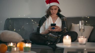 Kendini izole ederken akıllı telefonunda daktilo eden ciddi bir kadın.