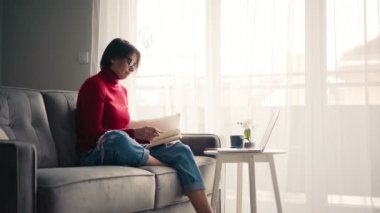 Gözlüklü orta yaşlı bir kadın bilgisayardan video görüşmesi yapıyor. 