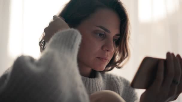 Close-up shot of a young woman watching a movie on her smartphone — Stock Video