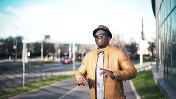 Joven hombre afroamericano alegre posando y bailando en la calle — Vídeo de stock