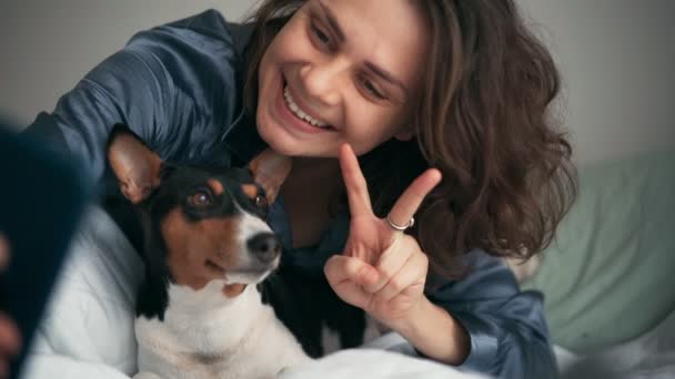 Una joven tomando una selfie con su smartphone con su perro basenji. — Vídeos de Stock