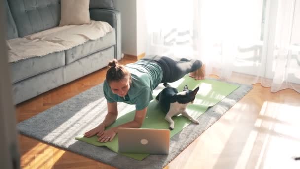 Belle jeune femme adulte prenant un cours de yoga en ligne — Video