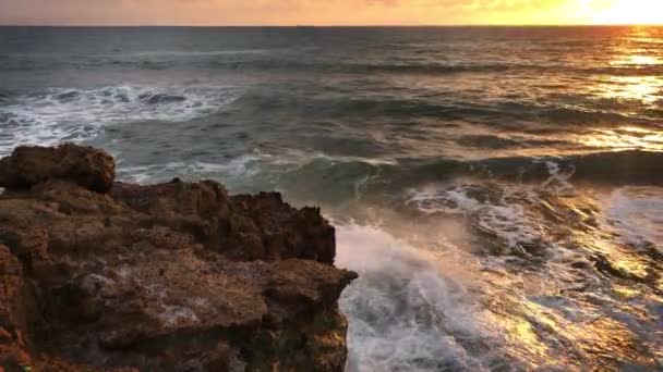 Vista dalla riva di grandi onde marittime che si infrangono contro le rocce in un tempo di tramonto — Video Stock